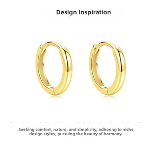 Macro shot of polished gold geometric hoop earrings with a shiny metallic surface