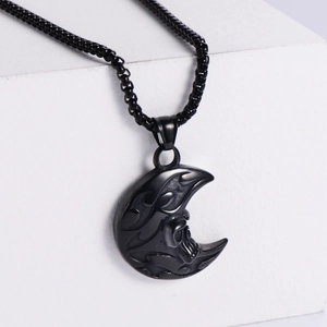 Vintage punk moon skull pendant in black finish with matching chain on white blocks