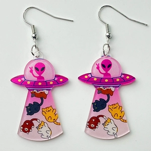 Detailed shot of pink acrylic UFO earrings with alien and cats being abducted design
