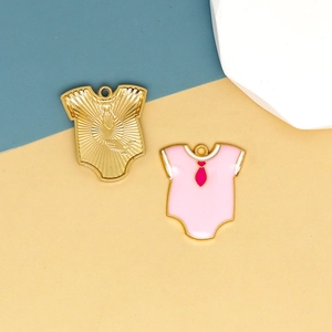 Detail of pink enamel baby bodysuit charms and gold hollowed metal pendants for DIY crafts