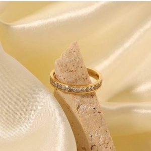 Detailed view of a gold-plated titanium ring with full square-cut zircon stones on a stone