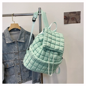 Dettaglio dello zaino trapuntato verde menta con texture morbida e design con coulisse