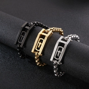 Three beaded bracelets with cross pendants in gold, silver, and black on a display