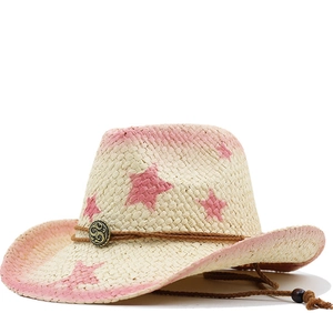 Detail of woven straw cowboy hat with pink stars and adjustable chin strap
