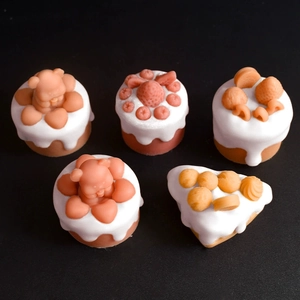 Macro detail of silicone molds showing bear, strawberry, and fruit cake shapes for DIY candles