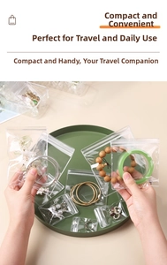 Transparent PVC jewelry storage pouches in various sizes shown on a dark green tray