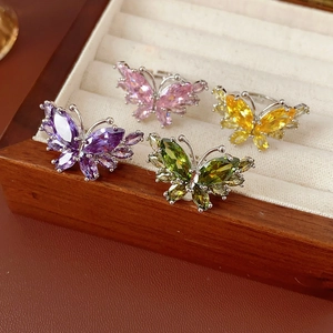 Vue détaillée de quatre bagues papillon ajustables serties de zircones colorées