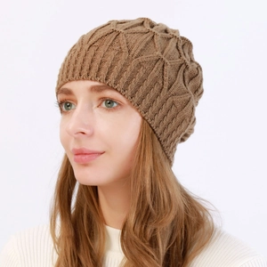 Detailansicht der braunen Zopfstrickstruktur und Rippkante an einer Winter-Beanie-Mütze