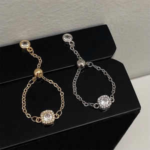 Detail view of adjustable gold and silver chain rings with sparkling zircon center stones