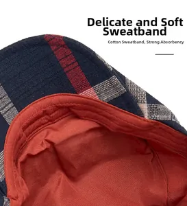 Detail of navy plaid beret featuring a soft orange cotton sweatband for sweat absorption