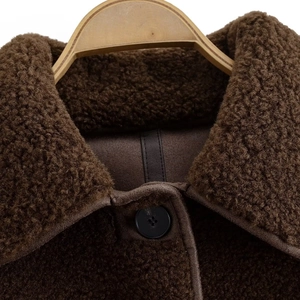 Détail du col d'une veste en polaire avec bouton noir et texture en mouton doux