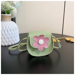 Close-up of a green PU leather child bag featuring a pink sequined flower and strap