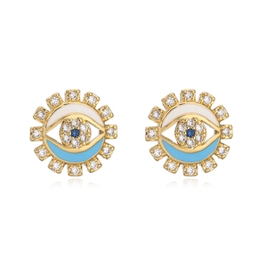 Macro shot of evil eye geometric earrings with gold plating and blue enamel inlay