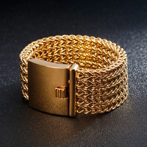 Macro detail of golden woven triple-row bracelet with large industrial metal clasp
