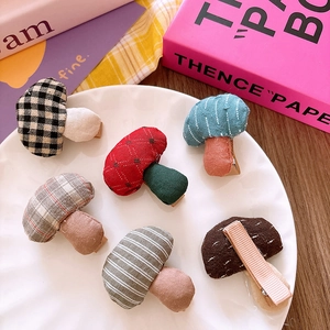 Macro shot of assorted checkered and polka dot mushroom-shaped fabric hair clips
