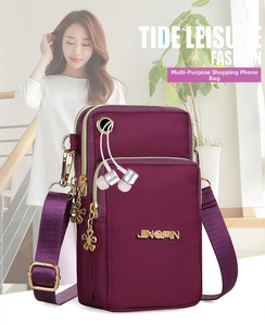 Detail view of purple nylon crossbody bag with three zipper pockets and adjustable strap