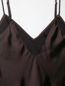 Vue détaillée du col en V et de la texture satinée sur la robe marron foncé