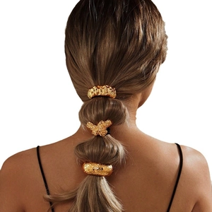 Golden irregular metallic ponytail holder set with textured finish on white background