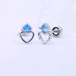 Detail view of heart-shaped silver earrings with sparkling blue crystal inlay