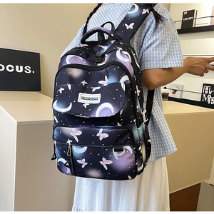 Detail of trendy black backpack with moon and butterfly prints showing the fashion label