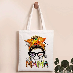 Close-up of Spooky MAMA print on white canvas tote bag with skeleton and pumpkin motifs
