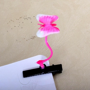 Detail of a pink and white gradient butterfly hair clip on a black hair clip base