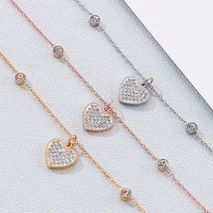Detailed close-up of heart charm bracelets in silver, gold, and rose gold with pavé crystals