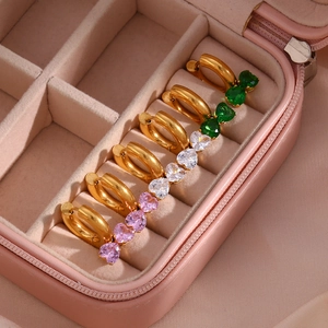 Close-up of heart-shaped zircon earrings in pink, white, and green in a gift box