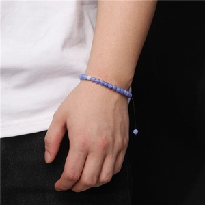 Close-up of a blue 6mm stone bead bracelet on a wrist with adjustable woven cord