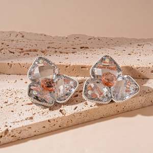 Macro shot of vintage crystal flower earrings with silver twisted borders and champagne stones