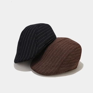 Close-up of navy and coffee striped wool newsboy caps showing thick fabric texture