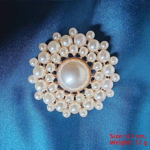 Detailed view of sunflower pearl brooch measuring 4.1cm and weighing 12g on blue silk