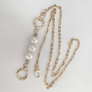 Close-up of golden replacement chain with large white faux pearls and metal spring clasps