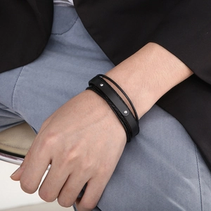 Bracciale multistrato da uomo in pelle nera con corda intrecciata sul polso del modello
