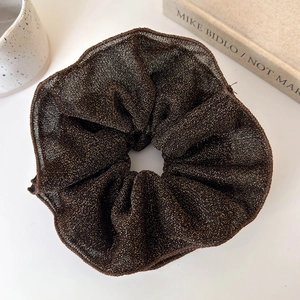 Close-up of deep brown double-layered scrunchie with gold glitter and soft fabric texture