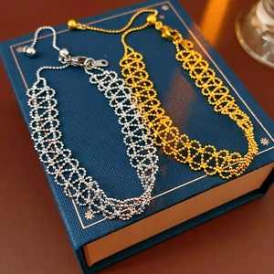 Close-up of gold and silver lace textured bead bracelets on a premium gift box