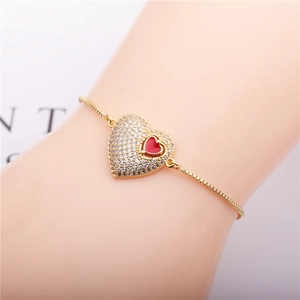 Adjustable gold plated heart bracelet featuring red enamel and sparkling zircons