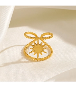 Detailed shot of an 18K gold plated eight-pointed star ring on white silk fabric