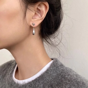 French minimalist silver lava teardrop earrings worn by model for elegant style