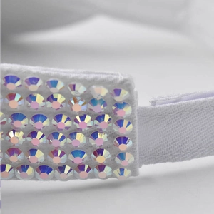 Macro view of white fabric sun visor strap with five rows of sparkling colorful rhinestones