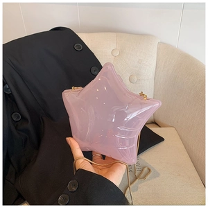 Close-up of pink transparent star-shaped acrylic crossbody bag with gold chain strap