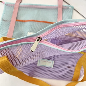 Gros plan du sac de plage en maille montrant la texture en nylon et la fermeture éclair