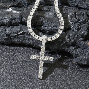 Silver iced-out cross pendant necklace with clear crystals on a textured rock base