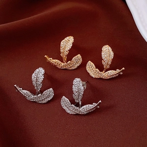 Detailansicht der 18k Gold und Silber Blatt Ohrringe mit Zirkonia auf Seide