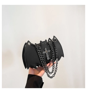 Close-up of black bat-shaped crossbody bag with silver chain and cross detail