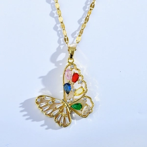 Détail d'un pendentif papillon doré avec des pierres précieuses colorées et ajourées