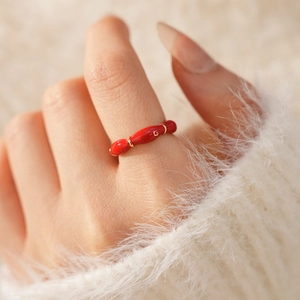 Detail shot of vintage red enamel oval ring with gold plating on model finger