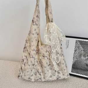 Close-up of floral tote bag with lace overlay and a large sequin bow decoration