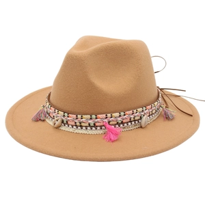 Camel felt fedora hat with ethnic shell decor and colorful tassels on white background