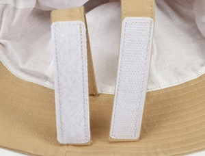 Detail of the adjustable hook-and-loop strap system inside the beige cotton sun hat